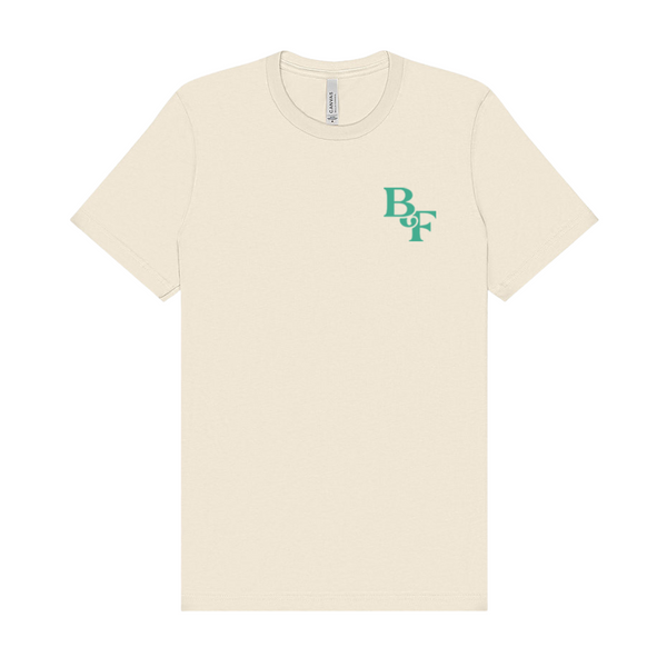 The Big Feastival 2025 Line Up T Shirt Natural by Big Feastival is a made-to-order, off-white short-sleeve tee with a small green B U F monogram on the left chest, crafted from 100% ring-spun cotton for softness and comfort.