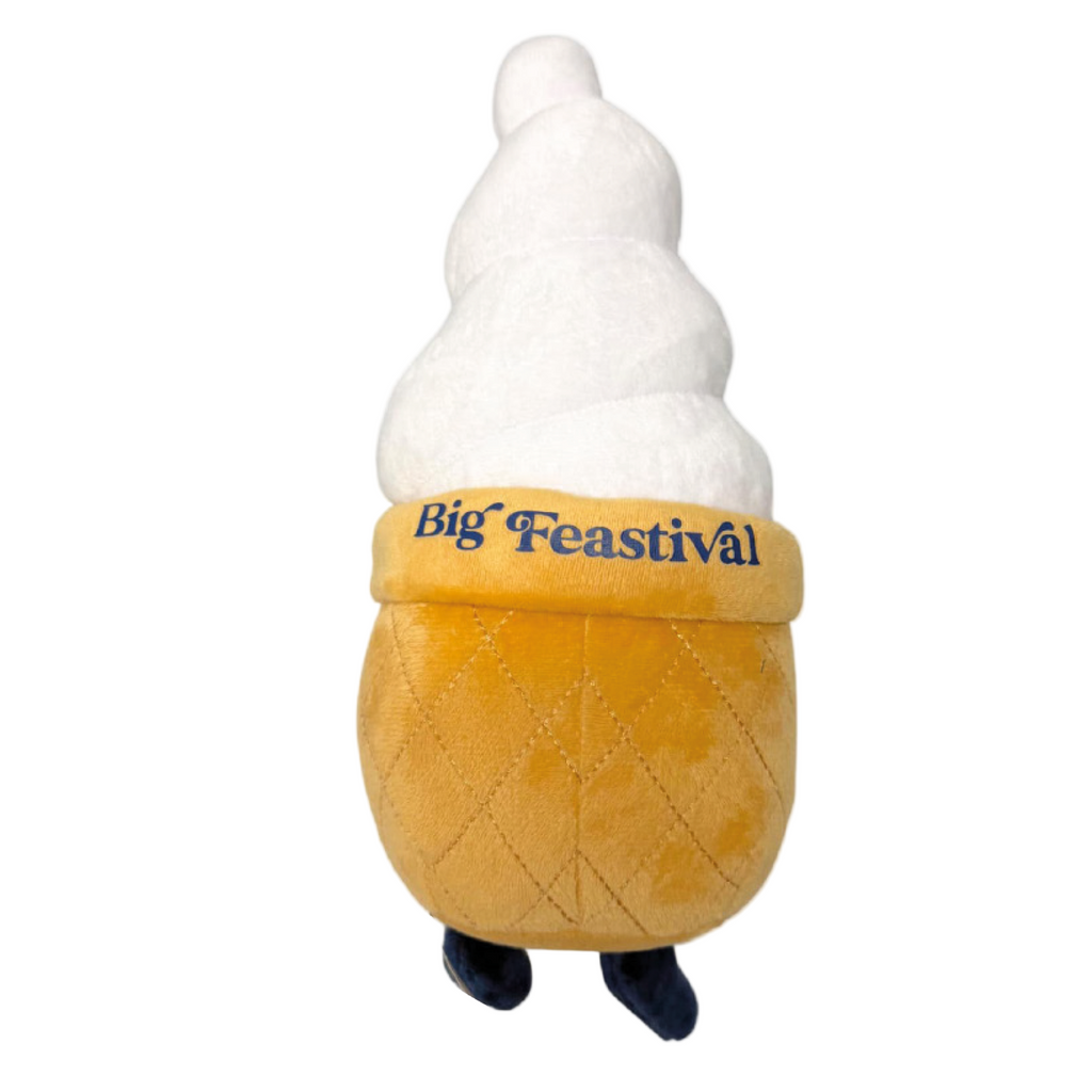 The Ice Cream Plush by 2025 is a soft toy shaped like a soft serve cone, featuring Big Feastival on the cone and two small black feet at the bottom.